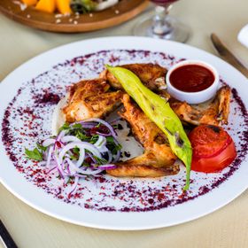 Charred garlic chicken wings on a platter, photo by Farhad Ibrahimzade on Pexels