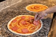 Person Holding Pizza on White Ceramic Plate