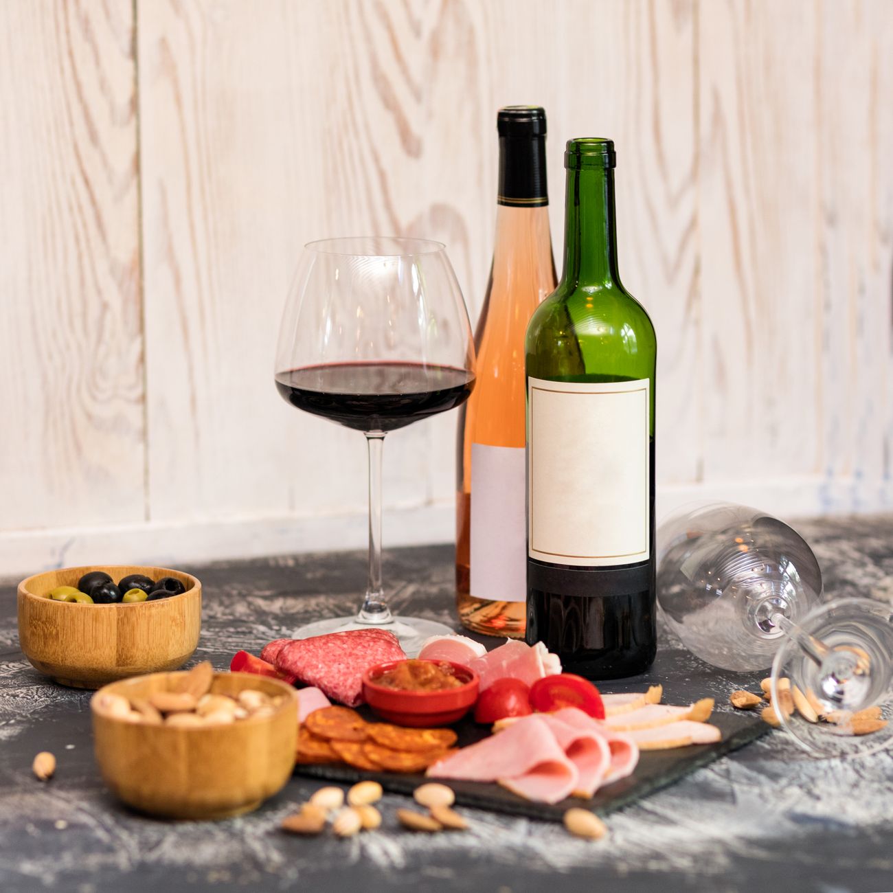 Sophisticated setup with wine and charcuterie on slate board, perfect for gourmet dining.