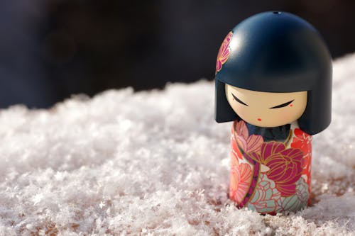A Japanese Wooden Doll on Snow