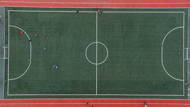 Aerial shot of a soccer match on a green field with players in Lviv, Ukraine.