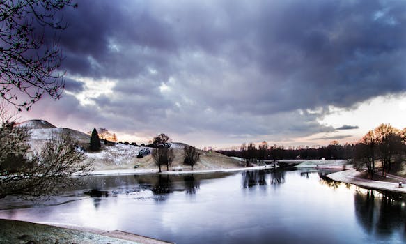 慕尼黑奥林匹亚公园的冬季日落景观美丽，倒映在冰冷的湖水中