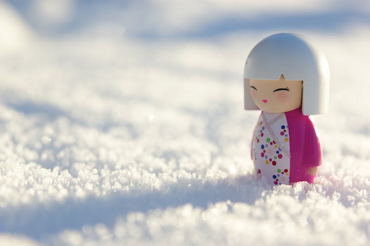 Wooden Japanese Doll On Snow