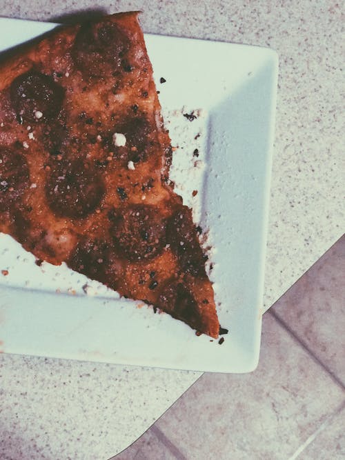 Slice of Pizza on White Ceramic Plate