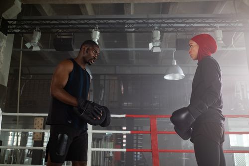 Free A focused boxing training session in a gym with a female athlete wearing a hijab and her personal trainer. Stock Photo