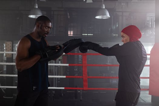 Two athletes training in a boxing gym with intense focus and dedication.