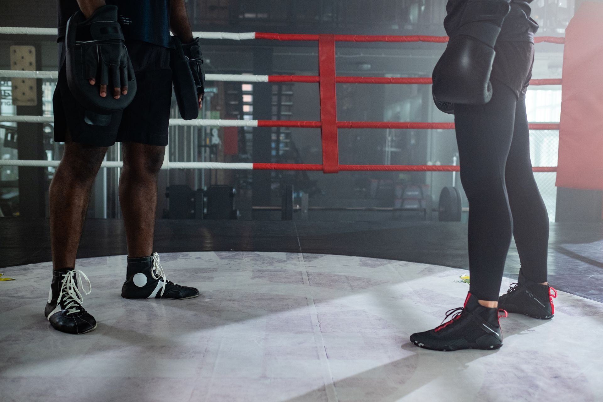 Man Wearing Boxing Pads Standing in Front of Person in Boxing Gloves