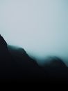 Atmospheric view of mist-covered mountain peaks for a mysterious, scenic feel.
