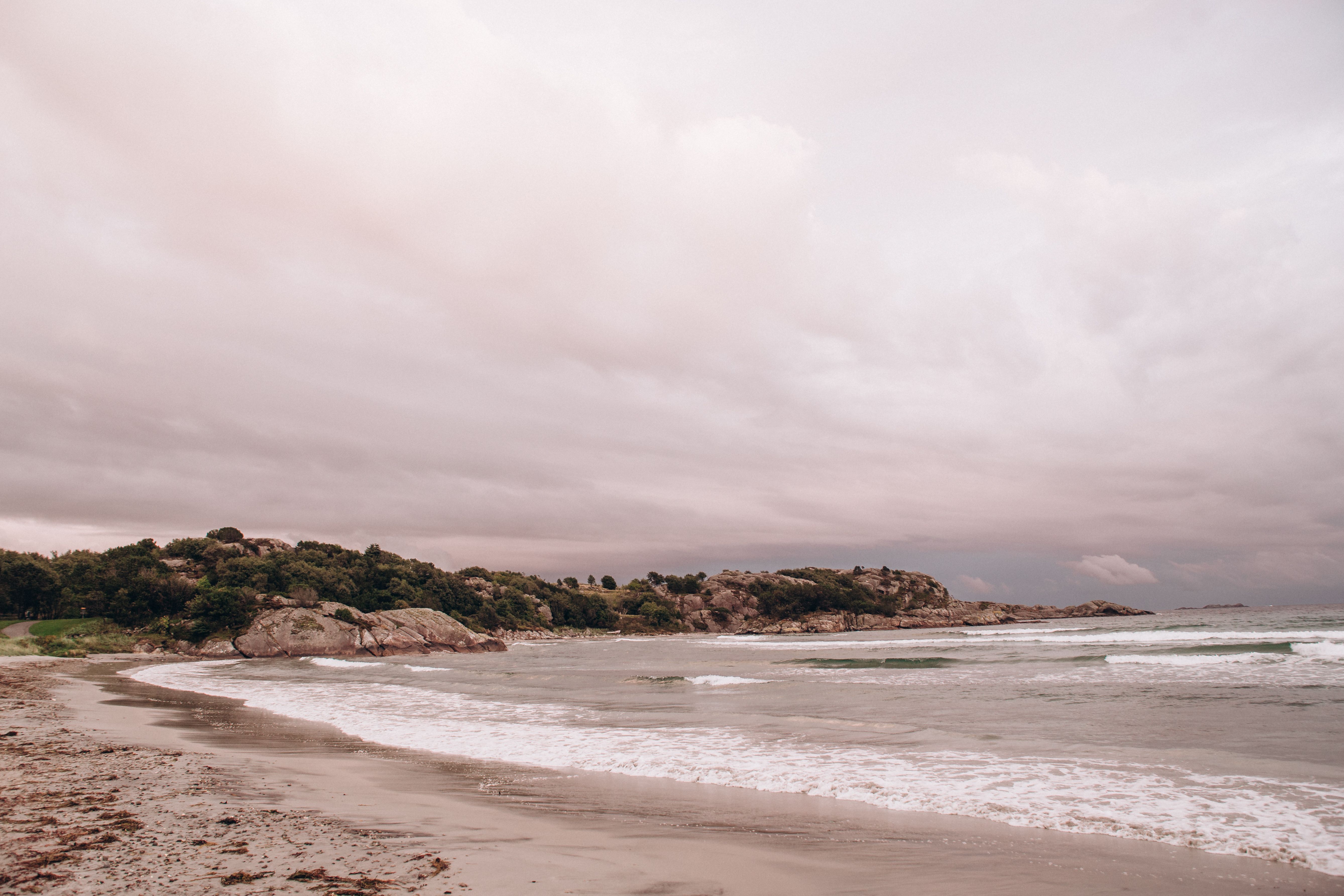 Peaceful beach landscape with waves and cloudy sky, perfect for serenity and nature themes.