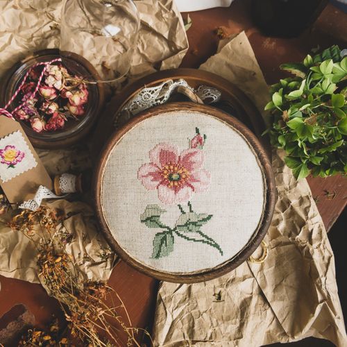 Free A charming flat lay of embroidery showcasing a pink floral pattern alongside rustic elements. Stock Photo