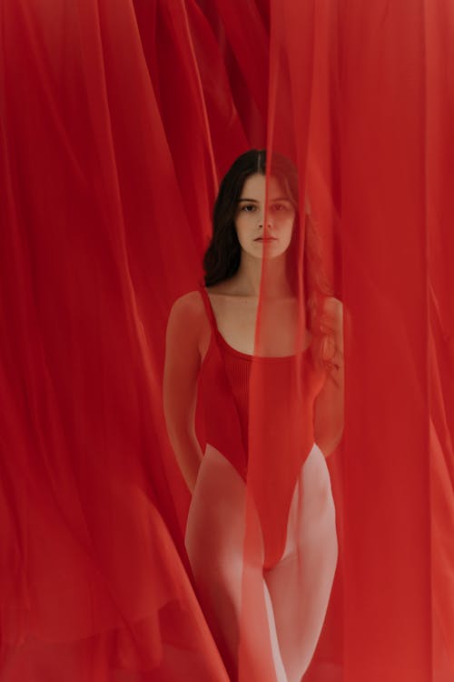 Woman Posing Among Red Curtains 