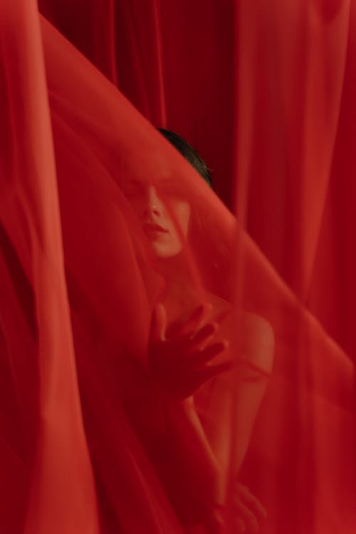Woman Posing Among Red Curtains 