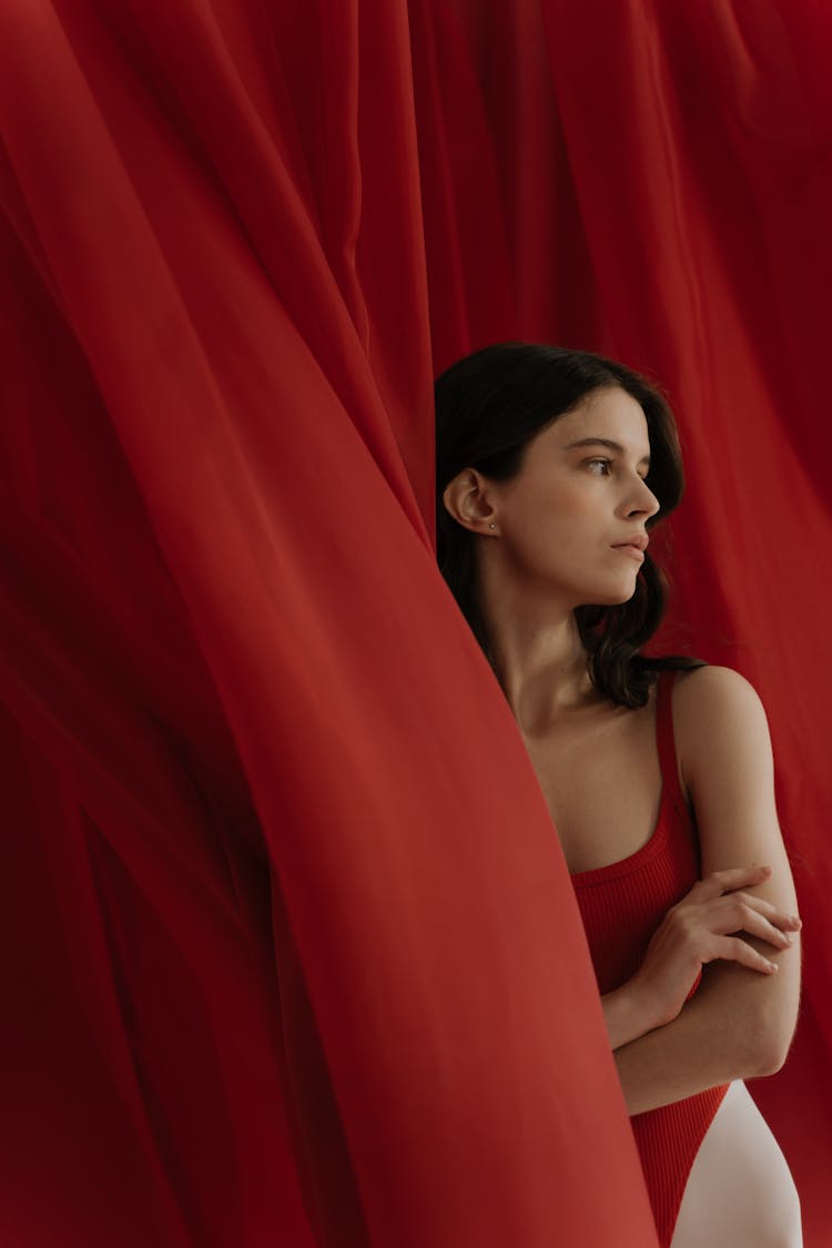 A Woman Behind The Curtain Wearing Swimsuit