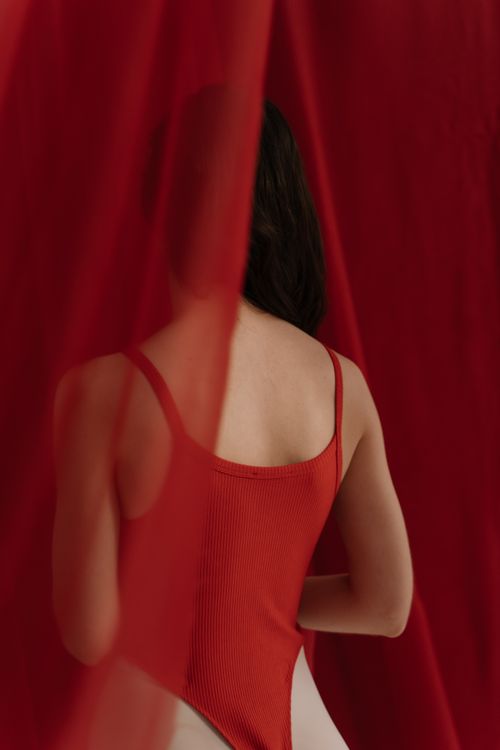 Free Artistic portrait of a woman in red with sheer fabric creating a sensual and mysterious atmosphere. Stock Photo