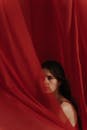一位部分被流动的红色织物遮盖的女人的艺术肖像