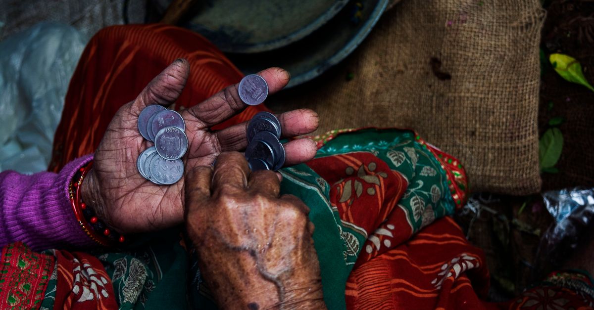 Rüyada Fakir Olduğunu Görmek - Rüya Tabiri ve Anlamı - Close-up of an elderly woman's hands counting coins on a colorful textile background.