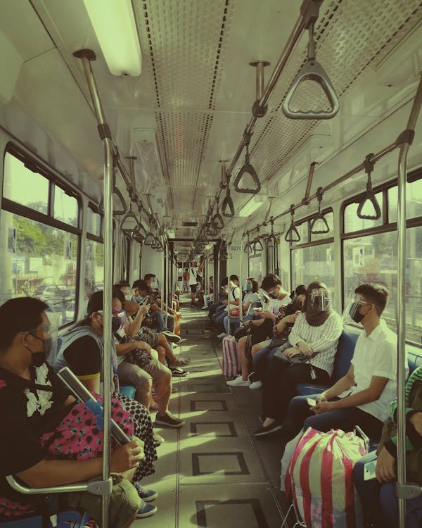 People in Face Masks Driving in Tram