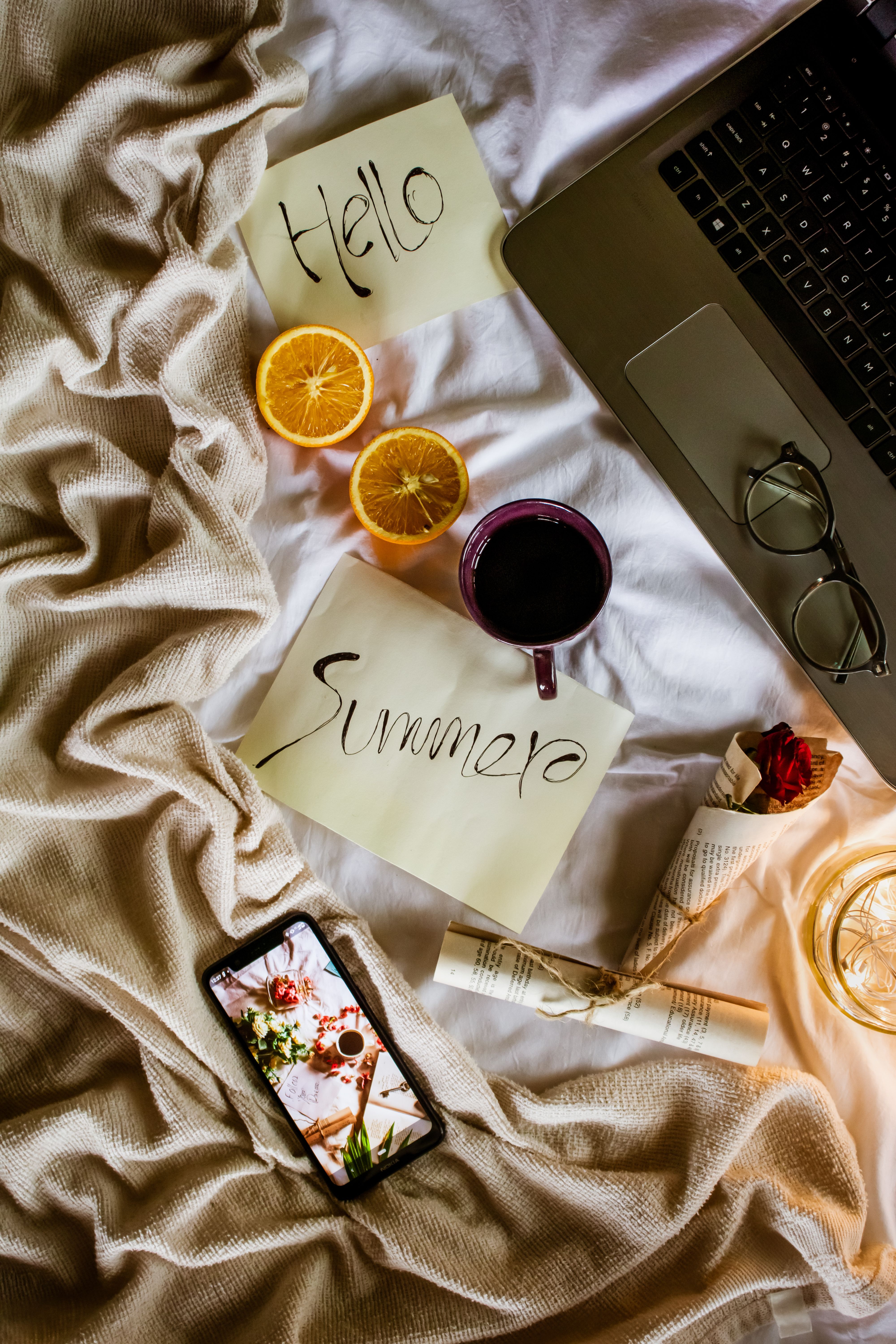 Stylish flat lay with a warm, summery vibe featuring citrus slices, coffee, and reading essentials.