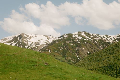 Free A tranquil view of snow-capped mountains under a partly cloudy sky. Stock Photo