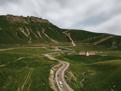 Aerial view of a winding road through the lush green mountains of Mtskheta-Mtianeti, Georgia.