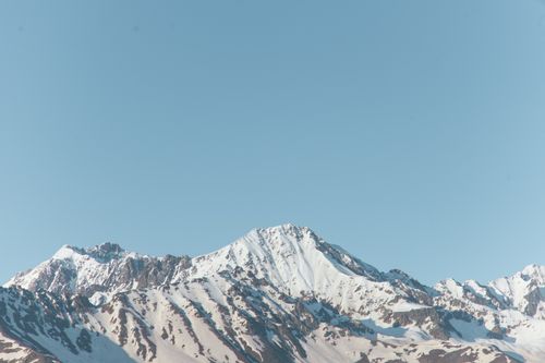 Free Captivating view of a snow-capped mountain range under a clear blue sky, perfect for nature enthusiasts. Stock Photo