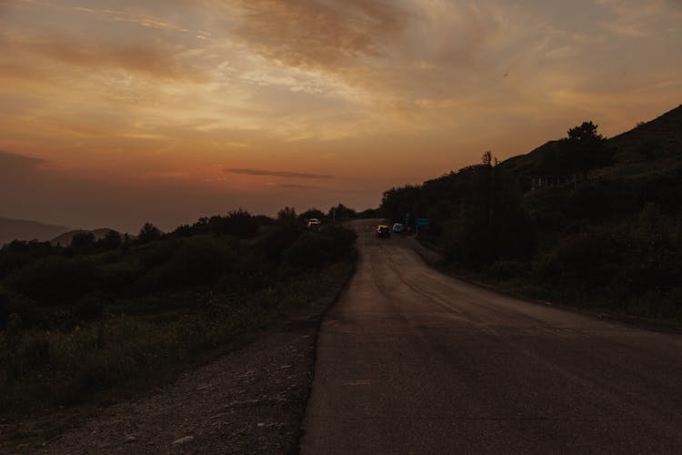 Cars Driving Road In Wild Nature On Sunset