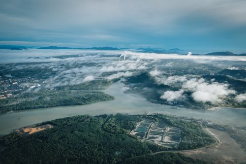 Free Stunning aerial view of Chukai, Malaysia showcasing lush greenery, river, and clouds. Stock Photo