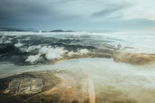 Aerial View From Above Clouds of a Coastal City 