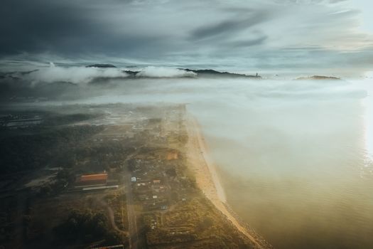A breathtaking drone shot of a misty seaside landscape at sunrise in Terengganu, Malaysia.