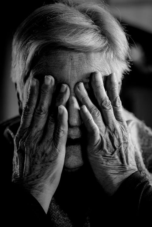 Elderly Woman Covering Her Face with Her Hands