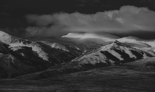 Free Black and white image of snow-capped mountains under dramatic clouds. Stock Photo