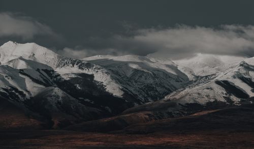 Free Dramatic view of snow-covered mountains under a cloudy sky, showcasing natural beauty. Stock Photo