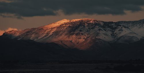 Free Breathtaking view of a snow-capped mountain range under a dramatic twilight sky. Stock Photo