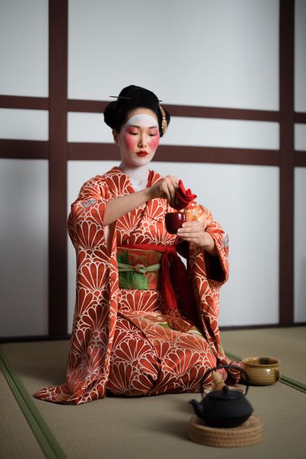 Geisha performing a serene tea ceremony in a traditional Japanese setting.