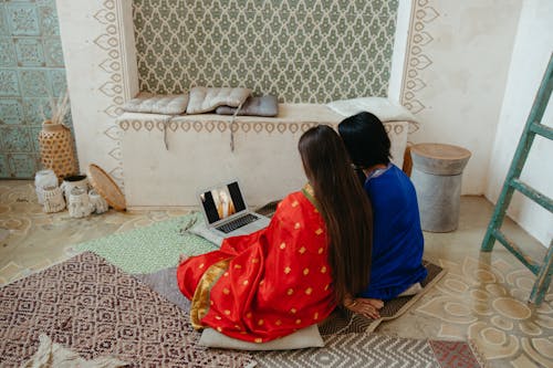 Women Sitting on the Floor Watching on a Laptop