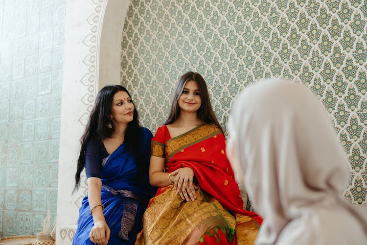 Women In Traditional Dresses Sitting Side By Side