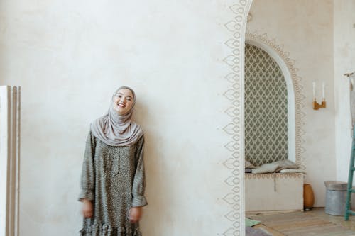 Woman in Gray Hijab Standing Near White Wall