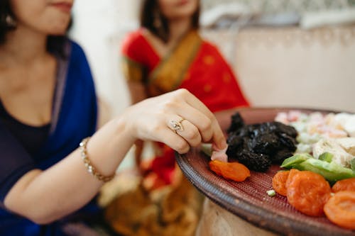 Women Wearing Sari Eating Vegetables 