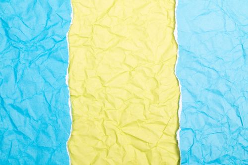 Free Vibrant crumpled paper design featuring blue and yellow hues in an abstract pattern. Stock Photo