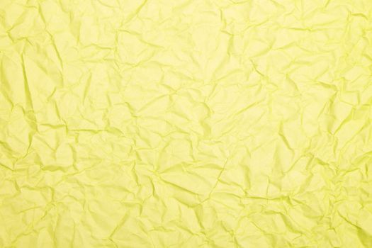 Crumpled yellow paper texture background with natural folds and wrinkles.