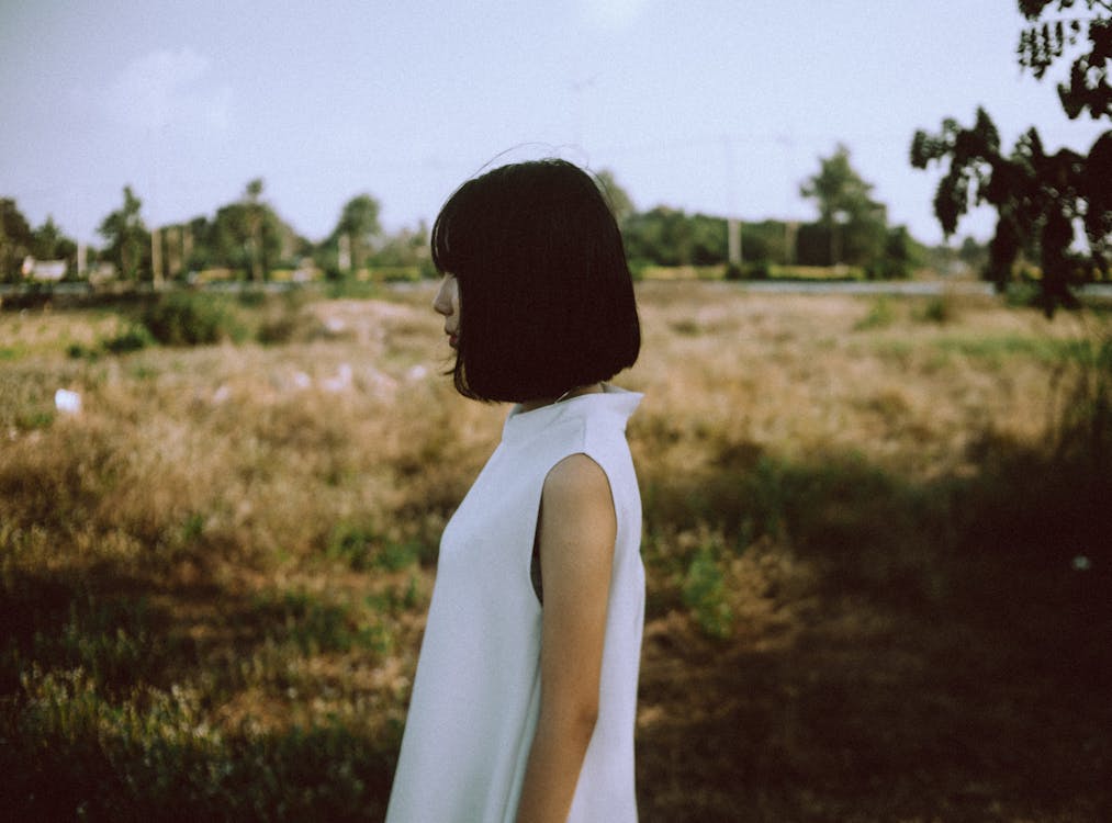 無料 茶色の芝生のフィールドの近くで白いノースリーブのドレスを着ている女性 写真素材