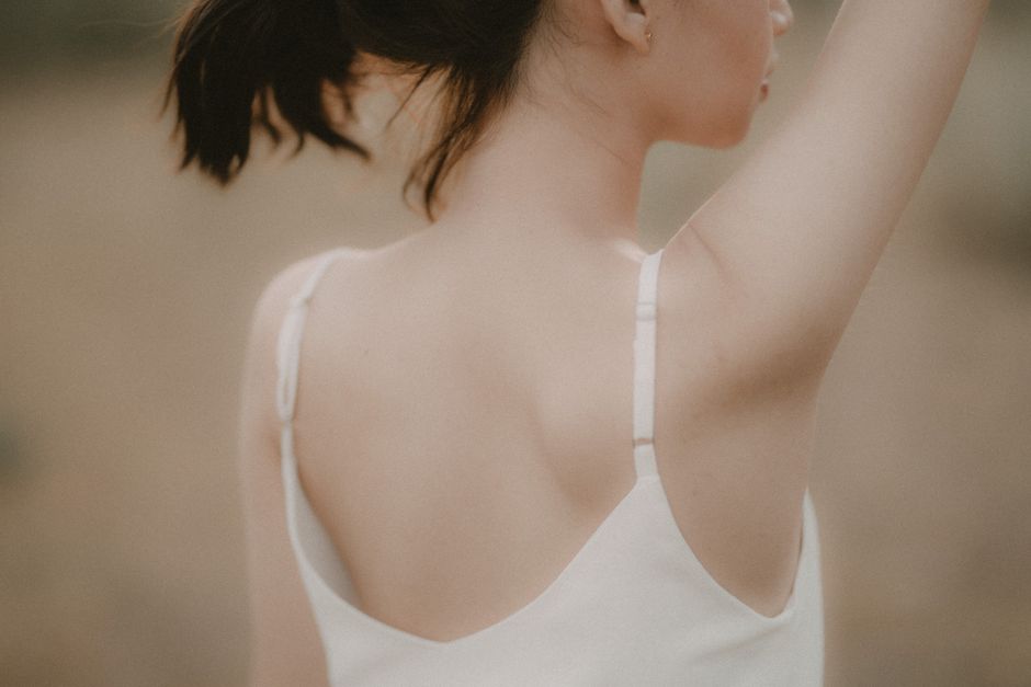 Person with clear, smooth back skin smiling confidently - deep cleansing back facial Person with clear, smooth back skin smiling confidently - deep cleansing back facial