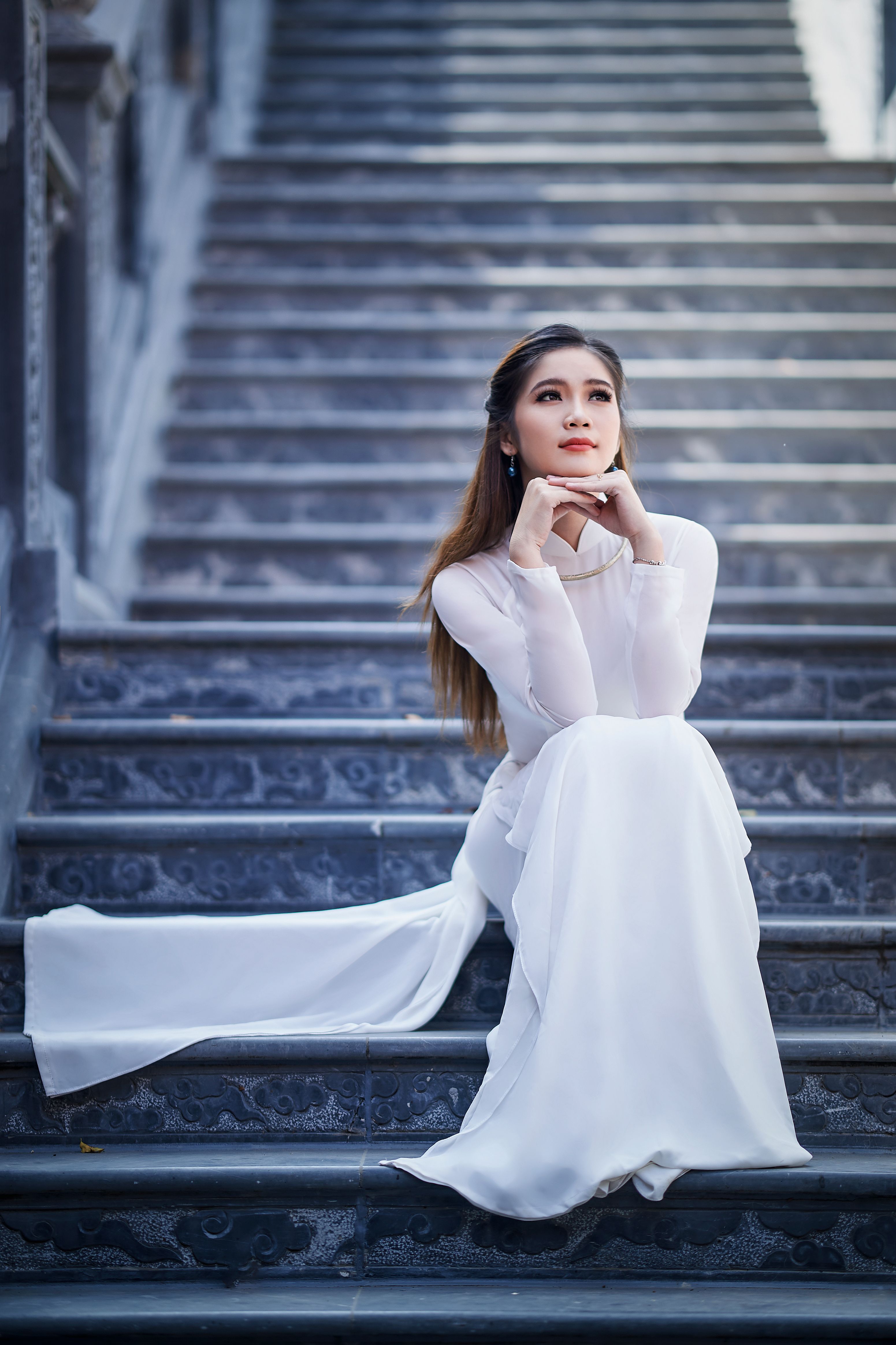 A Woman in White Long Sleeve Dress Sitting on the Stairs · Free Stock Photo