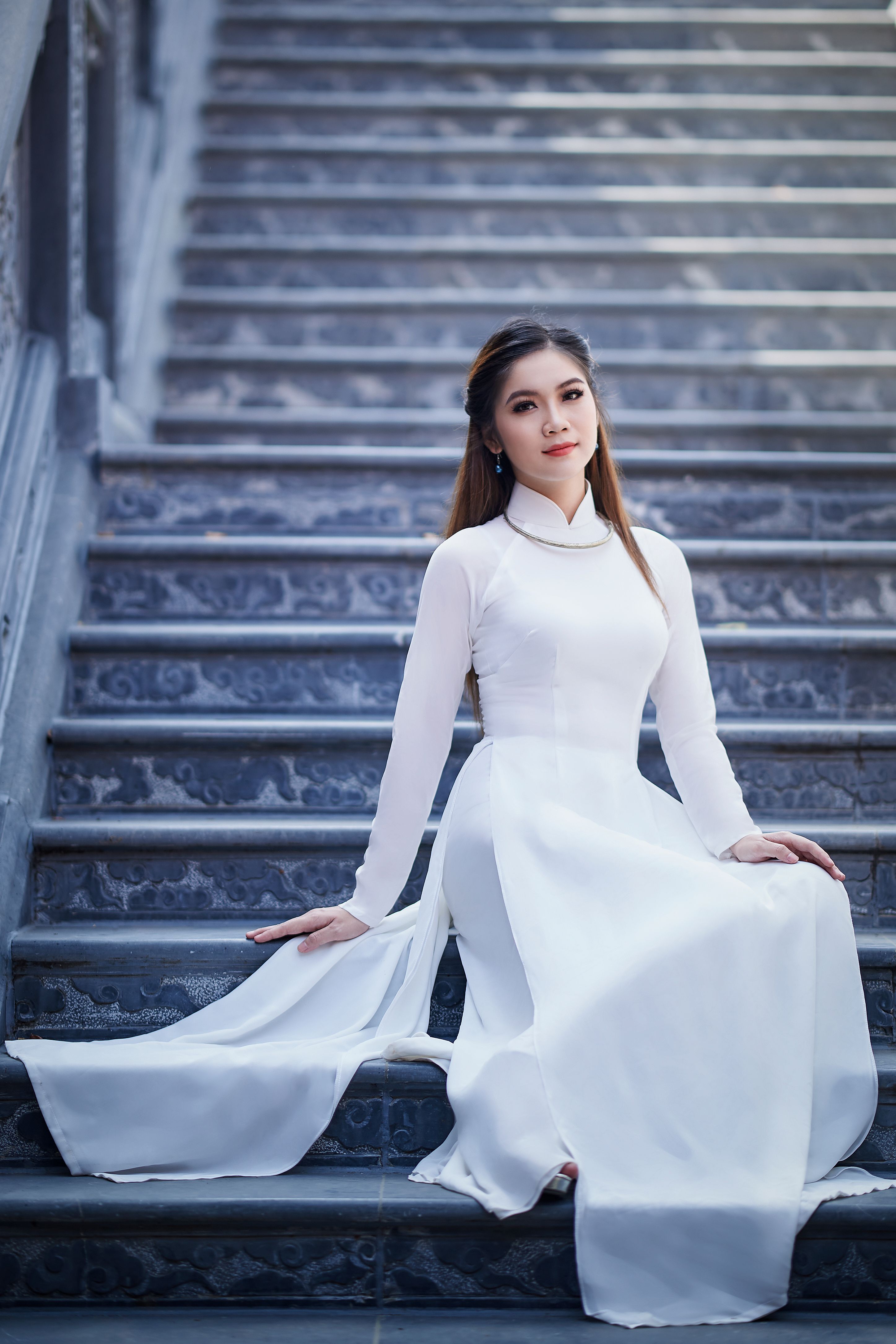 A Woman in White Long Sleeve Dress Sitting on the Stairs · Free Stock Photo