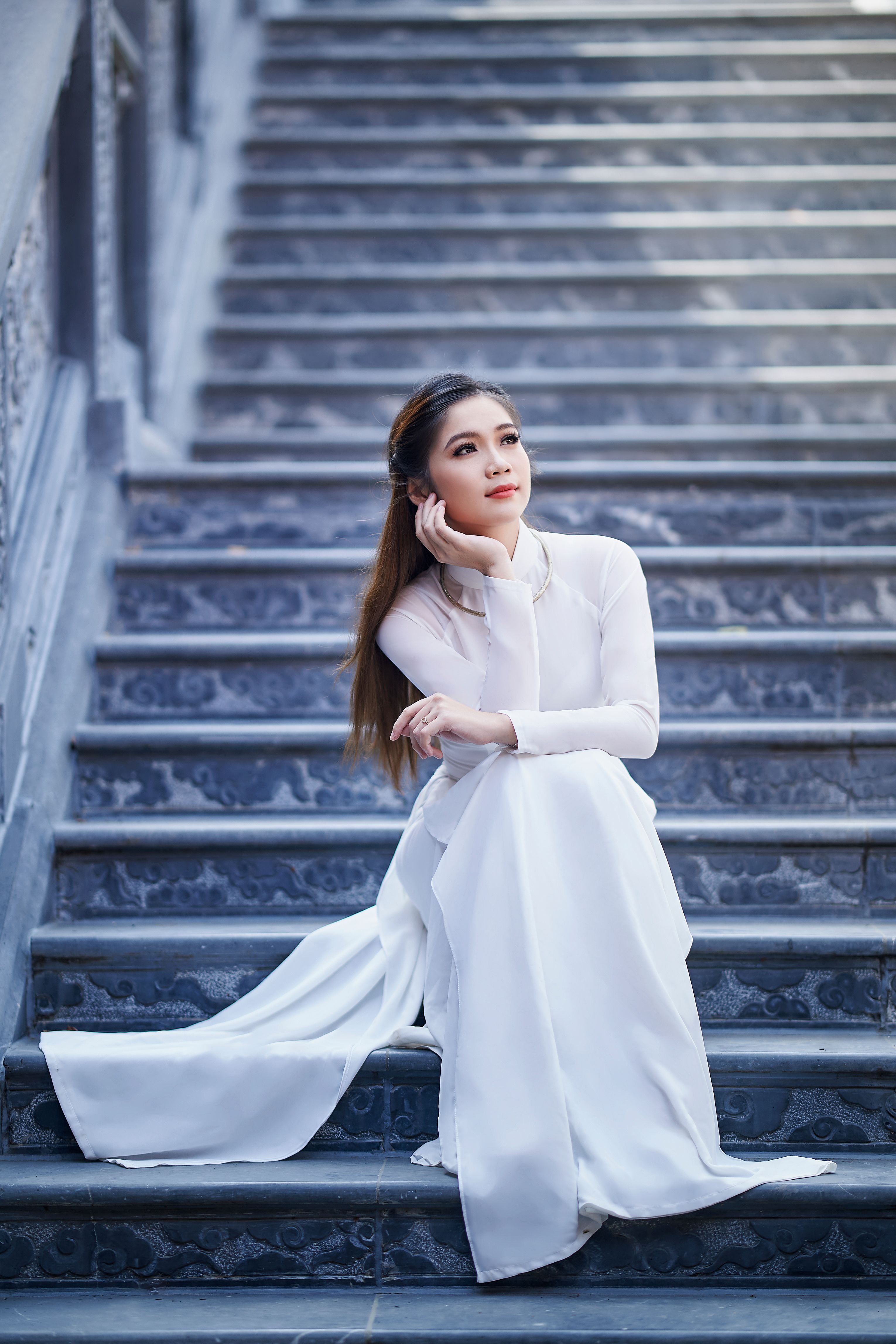 A Woman in White Long Sleeve Dress Sitting on the Stairs · Free Stock Photo
