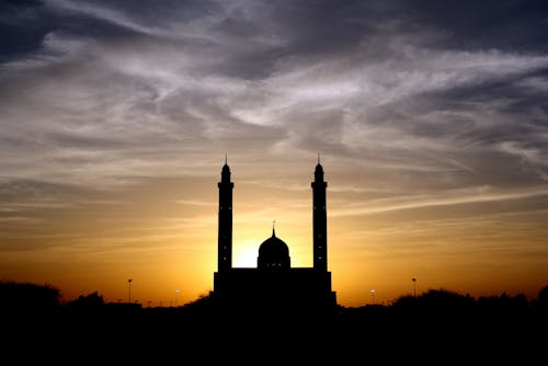 Silhouette of Mosque Below Cloudy Sky during Daytime