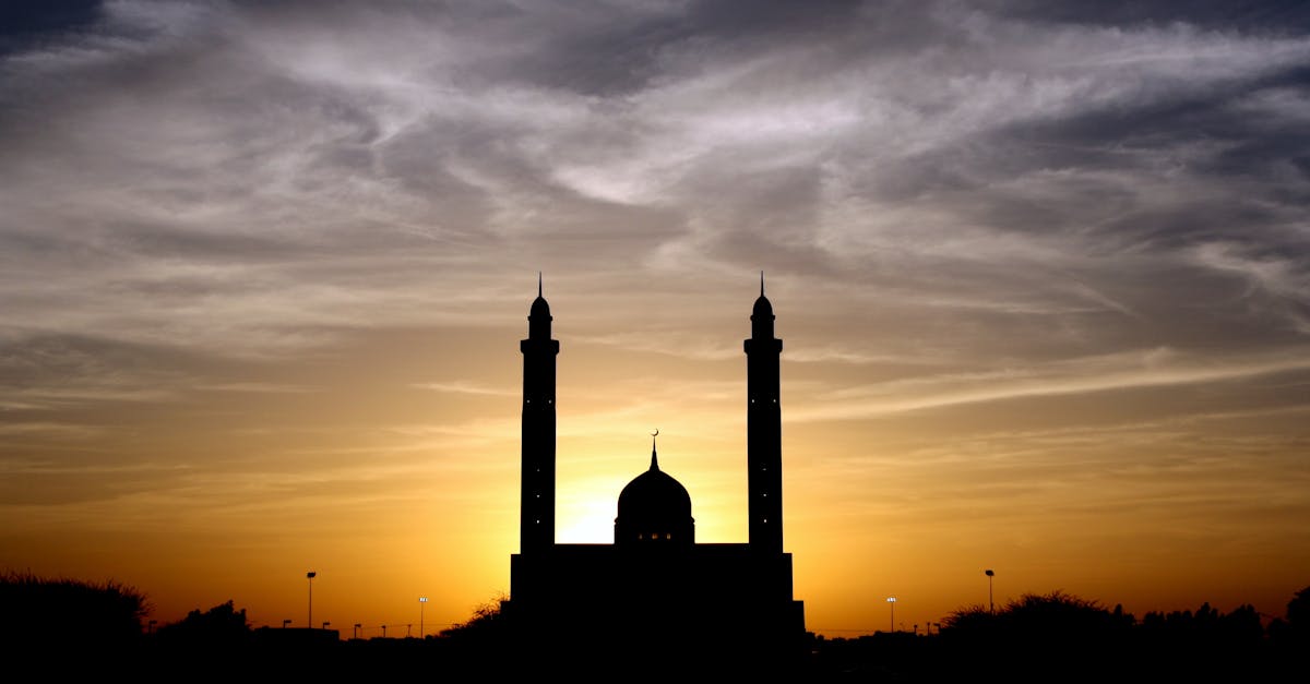 Silhouette of Mosque Below Cloudy Sky during Daytime