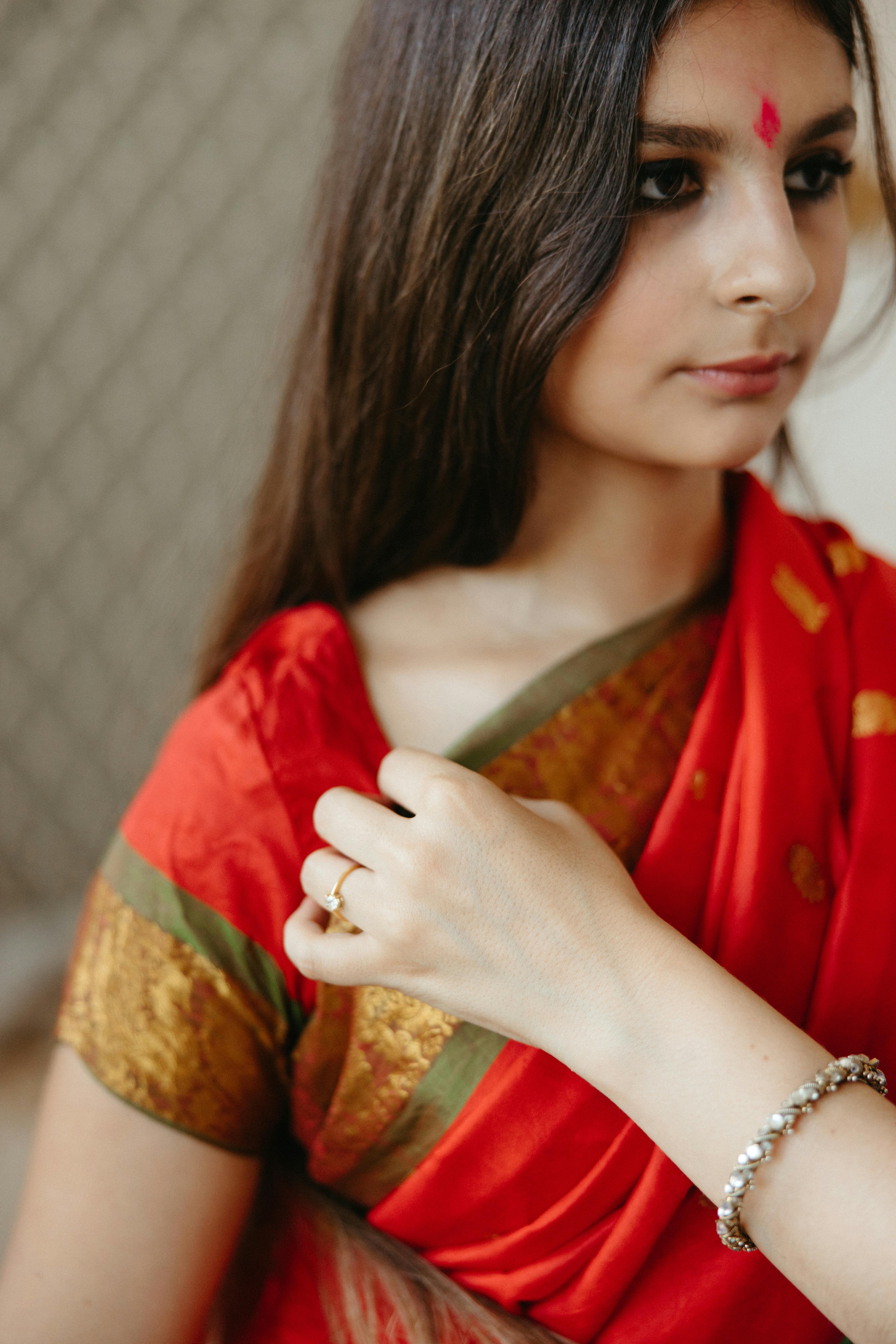 A woman in a red sari is posing for the camera photo – Free India Image on  Unsplash