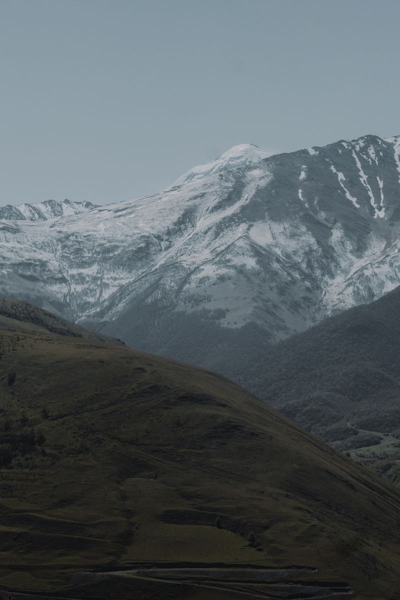 Majestic snow-covered mountains under a serene sky in North Ossetia, Russia.