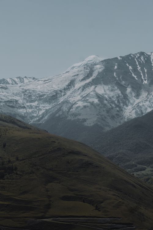 Free Majestic snow-covered mountains under a serene sky in North Ossetia, Russia. Stock Photo